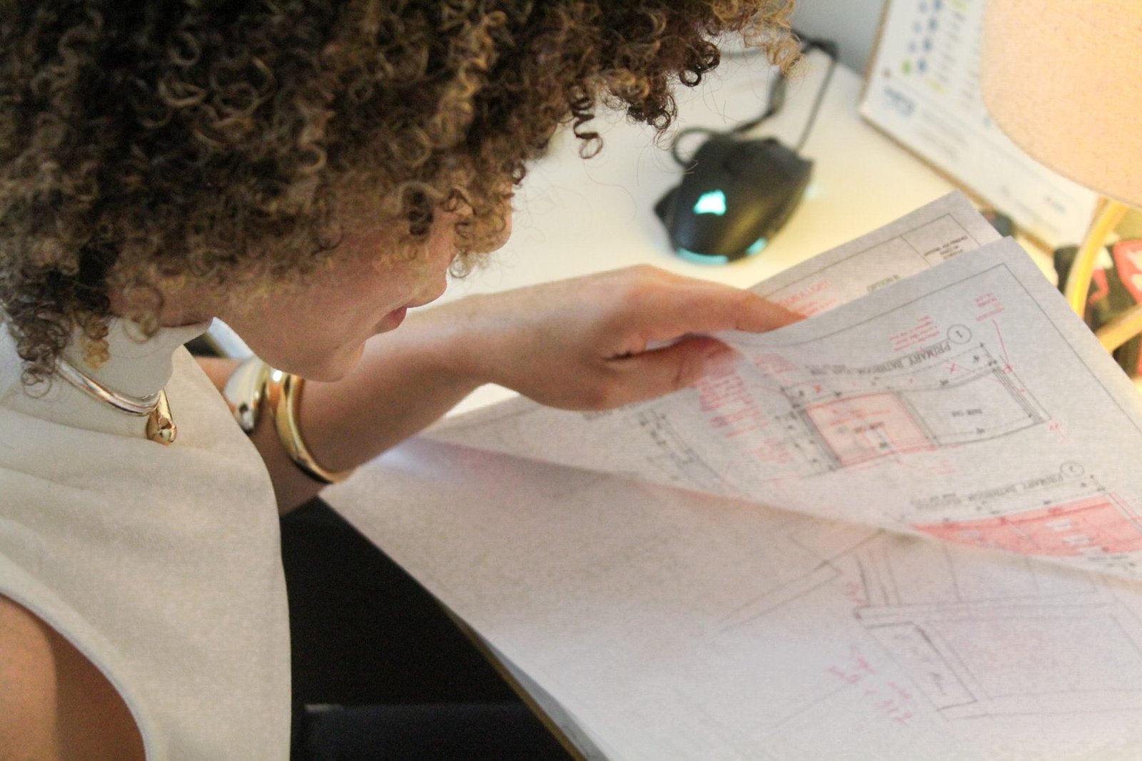 Taelor Design Build designer reviewing a dimensioned cabinetry elevation drawing at a drafting desk