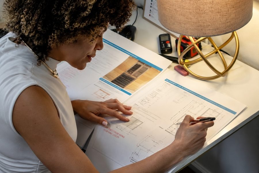 Thaise Barbosa of Taelor Design Build marking up a cabinetry shop drawing at her desk